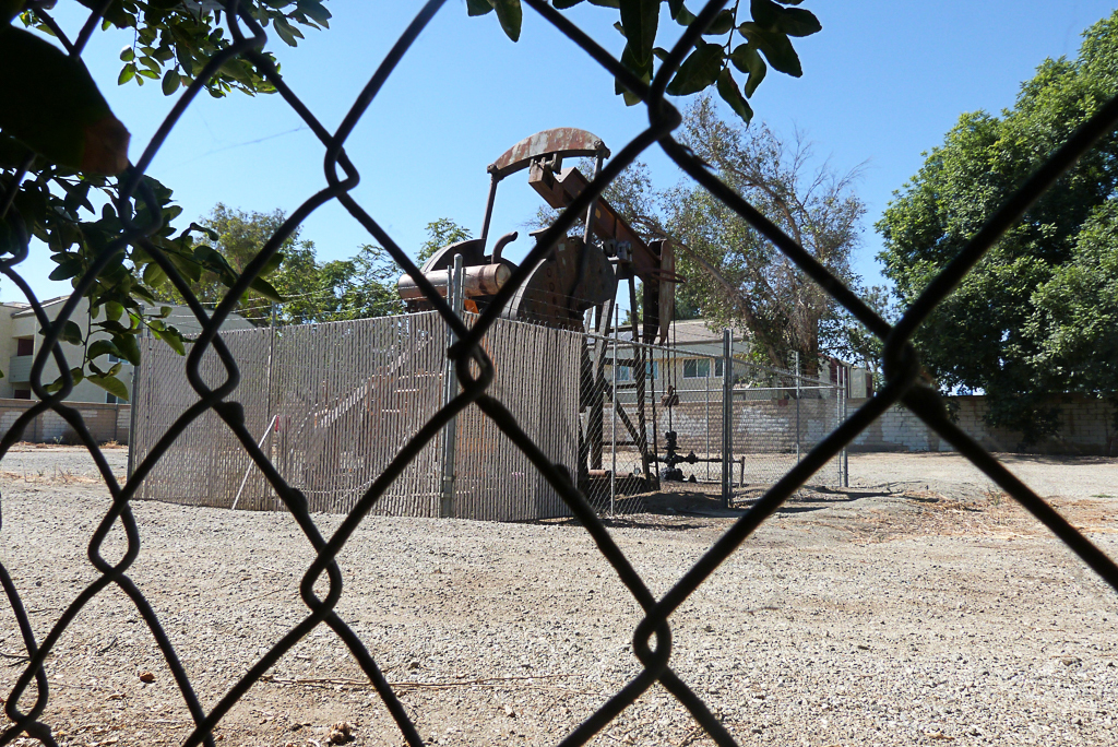 A pumpjack emits toxic gases as it extracts crude oil barely 25 feet from the home of a family in Arvin, California. Credit: Liza Gross/Inside Climate News