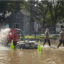 National Guard soldiers walk back by a water pump on a flooded street in Waterville, Minnesota on June 25. Credit: Christopher Mark Juhn/Anadolu via Getty Images