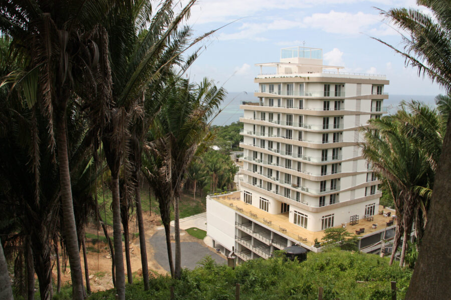 Honduras Próspera built a 14-story mixed-use tower perched at the bottom of a once-forested hillside near Crawfish Rock, a fishing village of a few hundred people on the island of Roatán. Credit: Nicholas Kusnetz/Inside Climate News