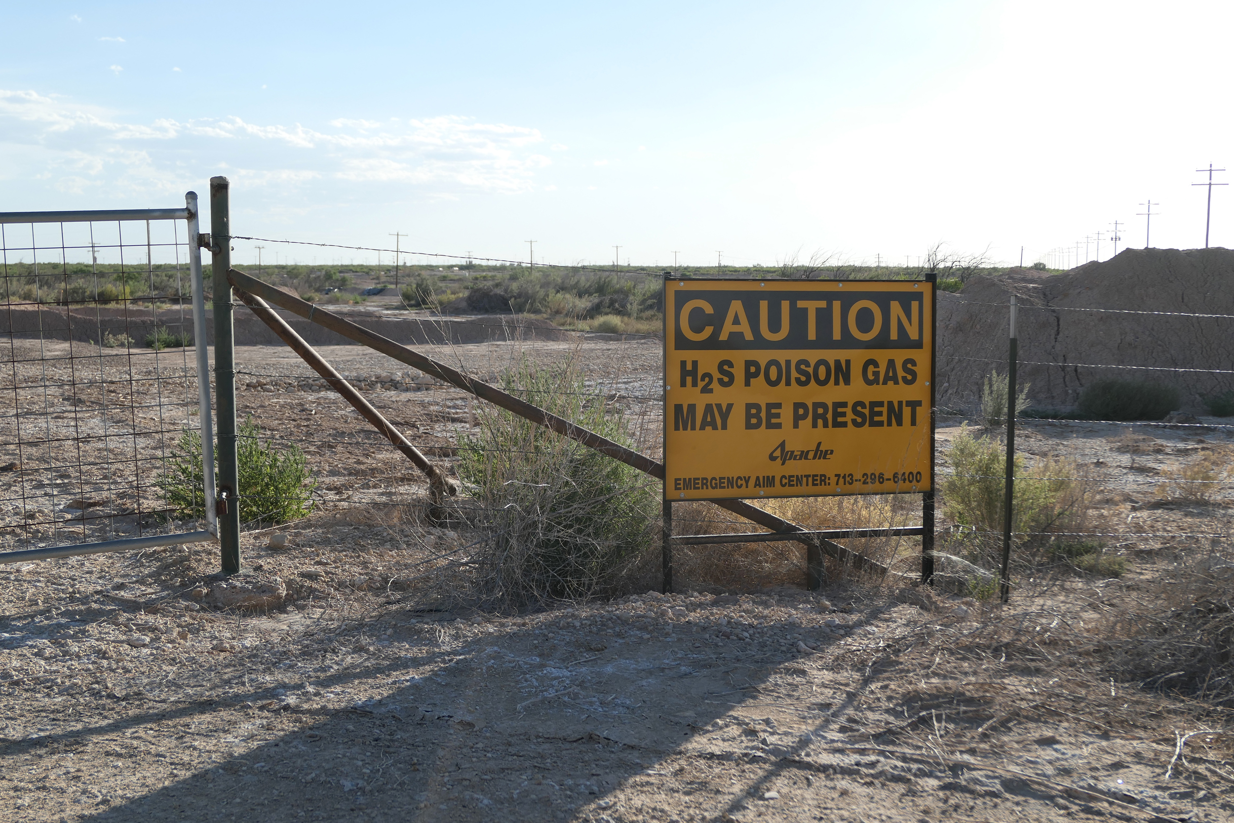 A sign warns of dangerous hydrogen sulfide gas at a drilling site in the Permian Basin in August 2023. Exposure to high concentrations of the gas can be lethal. Credit: Martha Pskowski