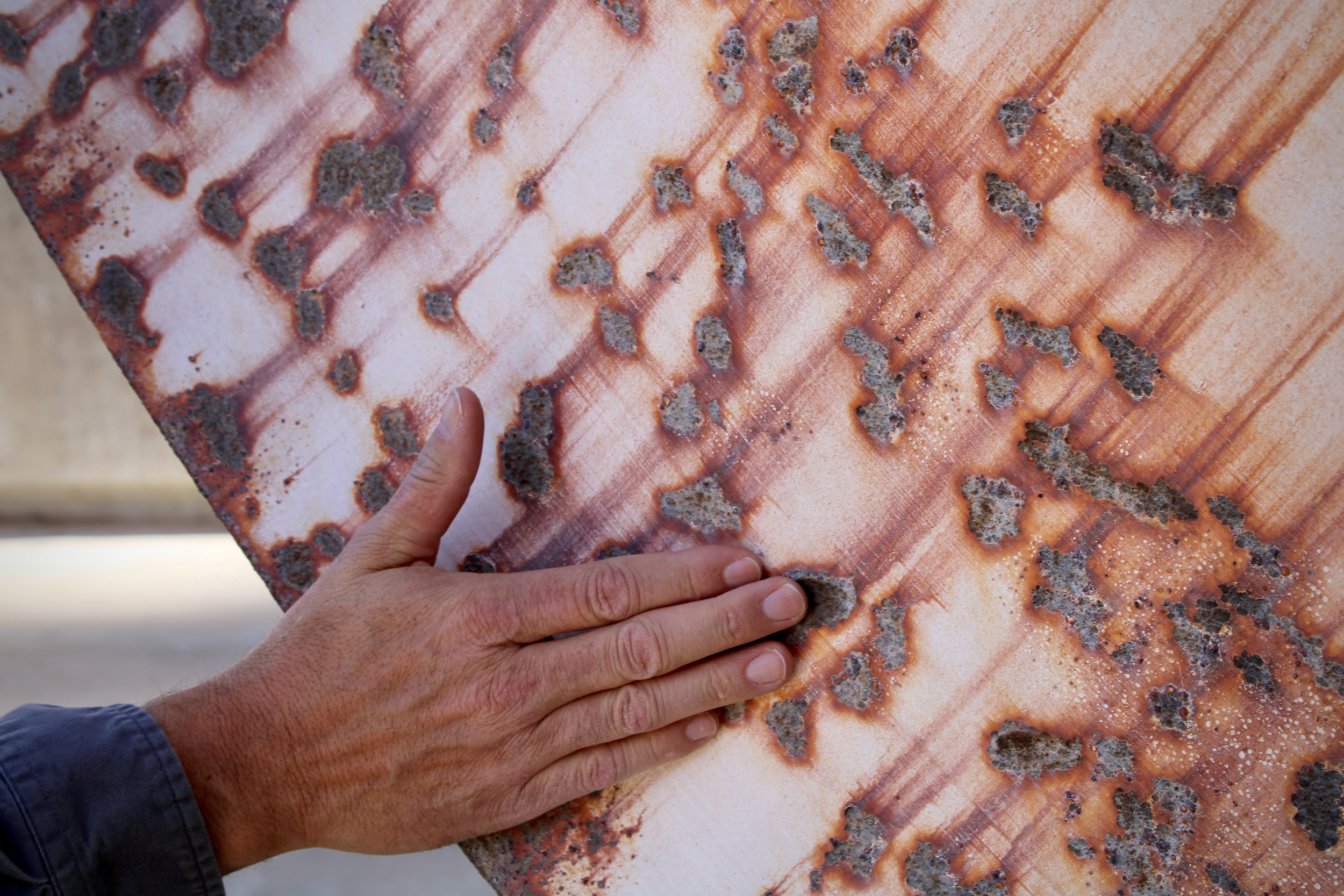 Bob Martin, who manages hydropower at Glen Canyon Dam, shows the effects of cavitation on a decommissioned turbine on Nov. 2, 2022. When air pockets enter the dam's pipes, they cause structural damage. Similar damage is the focus of upcoming repairs. Credit: Alex Hager/KUNC