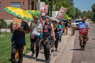 Activists in Pueblo, Colorado, march during a utility justice action organized by Mothers Out Front and 350 Colorado. Credit: Mothers Out Front