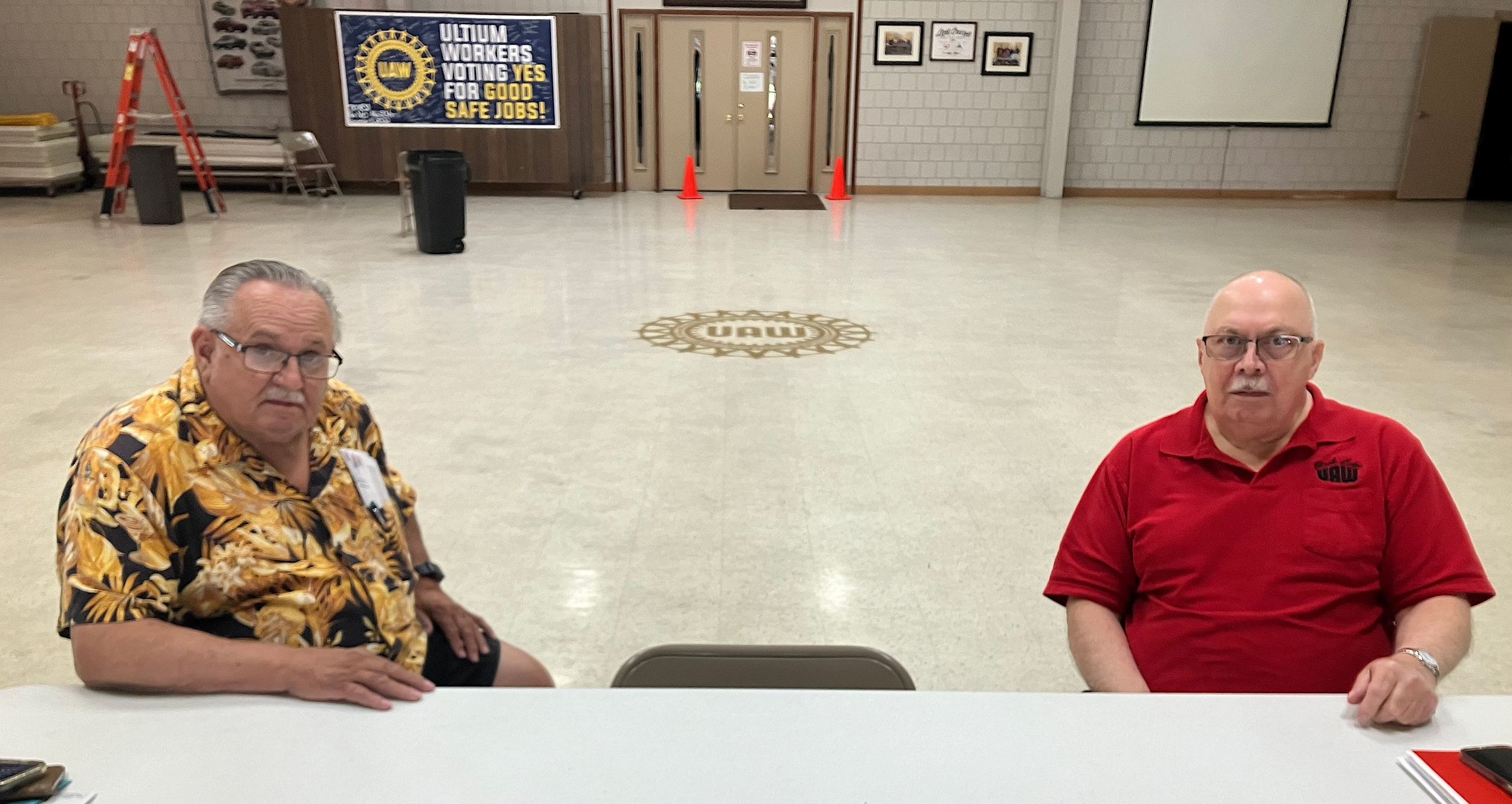Jim Devlin (left) and John Gordon greet visitors to the UAW Local 1112 hall in Lordstown, Ohio. They are retired auto workers have helped to keep the hall operating in the time since General Motors closed the Lordstown Assembly plant in 2019. Credit: Dan Gearino/Inside Climate News